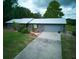 Charming single-Gathering home with a two-car garage, a well-maintained lawn, and a concrete driveway at 37149 Grays Airport, Lady Lake, FL 32159