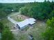 Aerial view of home with metal roof and spacious yard surrounded by lush trees and greenery at 37149 Grays Airport, Lady Lake, FL 32159