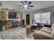 Cozy living room with unique decor, featuring modern ceiling fan, vinyl plank flooring, and comfortable seating at 37149 Grays Airport, Lady Lake, FL 32159