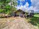 Outdoor building featuring metal roof, gravel base, and a tractor with large tires at 37149 Grays Airport, Lady Lake, FL 32159