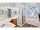 Bright bathroom featuring double vanity sinks, soaking tub, and glass-enclosed shower at 3732 Fallscrest Cir, Clermont, FL 34711