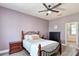 Well-lit bedroom featuring wood-look floors, a ceiling fan, and lavender walls at 3732 Fallscrest Cir, Clermont, FL 34711