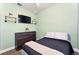 This is a nice bedroom with a mounted tv, floating shelves, and light green paint at 3732 Fallscrest Cir, Clermont, FL 34711