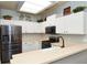 Well-lit kitchen featuring white cabinets, stainless steel appliances, and a skylight at 3732 Fallscrest Cir, Clermont, FL 34711