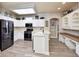 Spacious eat-in kitchen with white cabinets, modern appliances, and breakfast bar at 3732 Fallscrest Cir, Clermont, FL 34711