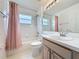 Bright bathroom featuring a tub with shower and vanity with large mirror at 3821 Doune Way, Clermont, FL 34711