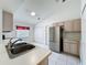 Bright kitchen featuring stainless steel appliances, light-colored cabinets, white tile floor, and natural light at 3821 Doune Way, Clermont, FL 34711