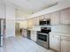 Well-lit kitchen featuring stainless steel appliances, light-colored cabinets, and open design to the dining area at 3821 Doune Way, Clermont, FL 34711