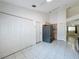 Kitchen with white cabinets and large refrigerator, with view into dining and living area at 3821 Doune Way, Clermont, FL 34711
