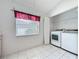 Bright laundry room featuring a window, tile flooring, and convenient washer and dryer at 3821 Doune Way, Clermont, FL 34711