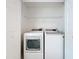 Laundry room with modern, efficient, white, side-by-side washer and dryer units and wire shelving at 3821 Doune Way, Clermont, FL 34711