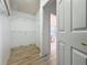 Walk-in closet with installed shelving, light laminate flooring and ensuite bathroom access at 3821 Doune Way, Clermont, FL 34711