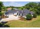 An aerial view of the home featuring a lush lawn, palm trees and large driveway at 39634 Harbor Hills Blvd, Lady Lake, FL 32159