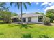 Home's exterior features a screened-in patio and a lush green yard at 39634 Harbor Hills Blvd, Lady Lake, FL 32159