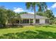 A charming home's backyard with mature trees and lush lawn creates a peaceful, private outdoor space at 39634 Harbor Hills Blvd, Lady Lake, FL 32159