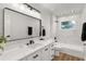 Bathroom featuring a shower/tub and vanity with quartz countertops, undermount sink and black hardware at 39634 Harbor Hills Blvd, Lady Lake, FL 32159