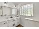 Bathroom with vanity with quartz countertops, undermount sink, and window with glass blocks at 39634 Harbor Hills Blvd, Lady Lake, FL 32159