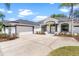 Exterior of a bright home featuring a large driveway, two-car garage and manicured landscaping at 39634 Harbor Hills Blvd, Lady Lake, FL 32159