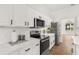 Modern kitchen with stainless steel appliances, quartz counters, and white cabinets at 39634 Harbor Hills Blvd, Lady Lake, FL 32159