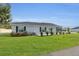 Backyard view of this home, showing the sliding glass door and landscaped bushes and lawn at 3984 Kanawha Pl, The Villages, FL 32163