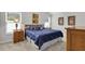 Bedroom featuring a blue bed, wood floors, and art on the wall at 3984 Kanawha Pl, The Villages, FL 32163