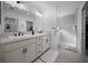 Modern bathroom featuring a double vanity with marble countertop and frameless glass shower at 4451 Elijah Loop, The Villages, FL 32163