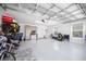 Spacious garage features epoxy floors, two windows, storage racks, and a clean, organized layout at 4451 Elijah Loop, The Villages, FL 32163