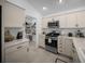 Well-lit kitchen featuring stainless steel appliances, a gas range, pantry and light countertops at 4451 Elijah Loop, The Villages, FL 32163