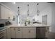 The kitchen has a large island featuring a sink, stainless appliances and stylish pendant lighting at 4451 Elijah Loop, The Villages, FL 32163