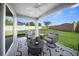 Relaxing screened-in patio with comfortable seating and a view of the green backyard at 4451 Elijah Loop, The Villages, FL 32163