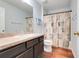 Functional bathroom featuring a vanity with storage and a shower with a decorative curtain at 4649 College Dr, Orlando, FL 32811