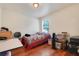Simple bedroom with hardwood floors, a window for natural light, and basic furnishings at 4649 College Dr, Orlando, FL 32811