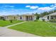 Single-story home with well-manicured lawn, a inviting blue door, and cozy porch at 4649 College Dr, Orlando, FL 32811