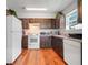 Functional kitchen with wood cabinets, white appliances, and hardwood flooring for a warm feel at 4649 College Dr, Orlando, FL 32811
