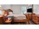Comfortable main bedroom with hardwood floors, a wooden bed frame, and dresser at 4649 College Dr, Orlando, FL 32811