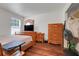 Well-lit main bedroom with hardwood floors, a TV, and plenty of storage with two dressers at 4649 College Dr, Orlando, FL 32811