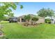 Backyard with an enclosed lanai, lush lawn, and landscaping offers a private and serene outdoor space at 467 Weston Manor Dr, The Villages, FL 32162