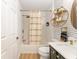 Stylish bathroom features tile surround, gold fixtures, floating shelves, and a decorative mirror for a modern aesthetic at 467 Weston Manor Dr, The Villages, FL 32162