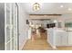 Bright, open-concept floor plan with wood floors and exposed beams, connecting the kitchen, dining, and living areas at 467 Weston Manor Dr, The Villages, FL 32162