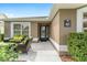 Inviting front porch with stylish outdoor seating, lush landscaping, and the home's address plaque at 467 Weston Manor Dr, The Villages, FL 32162