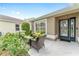 View of the front porch with cozy outdoor seating, a welcoming entrance, and colorful garden at 467 Weston Manor Dr, The Villages, FL 32162