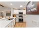 Well-lit kitchen with white cabinets, stainless steel appliances, and a pass-through counter for dining at 467 Weston Manor Dr, The Villages, FL 32162