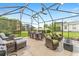 Covered patio with ceiling fans, wicker seating, dining table, and a fire pit create a relaxing outdoor living space at 467 Weston Manor Dr, The Villages, FL 32162