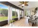 Bright sunroom features large windows, wood-look floors, comfortable seating, and scenic views of the outdoors at 467 Weston Manor Dr, The Villages, FL 32162