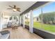 Bright sunroom features large windows, wood-look floors, comfortable seating, and scenic views of the outdoors at 467 Weston Manor Dr, The Villages, FL 32162