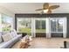 Bright sunroom features large windows, wood-look floors, comfortable seating, and scenic views of the outdoors at 467 Weston Manor Dr, The Villages, FL 32162