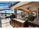 Elegant outdoor living space with screened pool, outdoor kitchen, and dining area with lake views at 4835 Calasans Ave, St Cloud, FL 34771