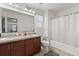Double vanity bathroom with large mirrors, granite countertops, and a shower/tub combo with a white curtain at 4869 Grassendale Ter, Sanford, FL 32771