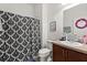 Cozy bathroom featuring a shower with black and white patterned curtain, granite countertop vanity, and decor at 4869 Grassendale Ter, Sanford, FL 32771