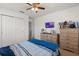 Bedroom featuring a bed with blue bedding, closet, mounted television, and wooden dresser at 4869 Grassendale Ter, Sanford, FL 32771